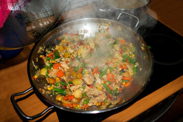 Gemüse in einem Wok angedünstet, Deckel öffnen läßt es dampfen