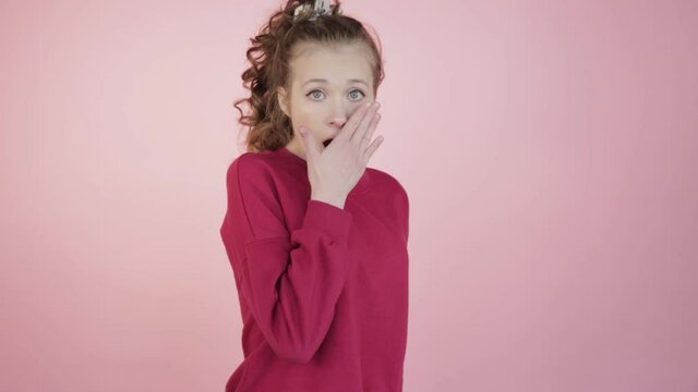 The girl with her eyes wide open was frightened. A hand near the mouth.