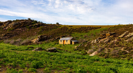 Obraz premium A Tiny Stone Cabin Sits On This Cold Hill In Otago