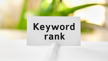 Keyword rank - business seo concept text on a white notebook and green flowers