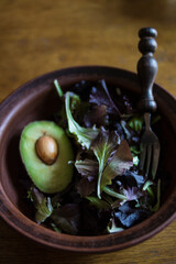 Fresh green tasty avocado lies in clay natural dishes on a wooden oak table
