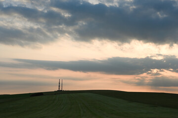 Fototapeta na wymiar beautiful sunset with a telecoms or radio mask on the horizon with a dramatic sky 