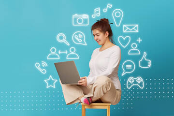 Woman is siting in lotus position on a chair with a laptop.