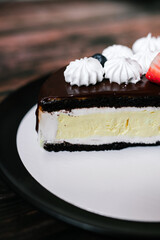 cheesecake cake cut with chocolate on a black plate