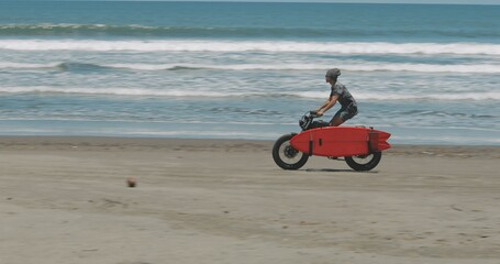 Motorcyclist driving his motorbike on the beach