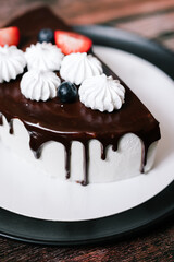 cheesecake cake cut with chocolate on a black plate