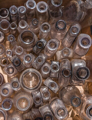 An overhead perspective of a collection of old clear glass bottles
