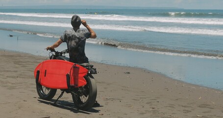 Obraz premium Motorcyclist driving his motorbike on the beach