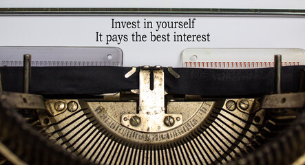 Text 'invest in yourself it pays the best interest' typed on retro typewriter. Business concept. Beautiful background.