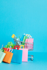 Fototapeta premium Shopping basket full of paper bags. Sesonal sale, online deals, discounts, promotions idea