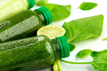 Lined up on a white counter chilled drinks made from fresh ripe fruits and vegetables surrounded by limes