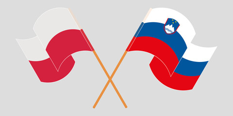 Crossed and waving flags of Slovenia and Poland