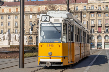 Fototapeta na wymiar Iconic Budapest yellow Tram trolley at Kossuth monument near parliament building in sunny morning