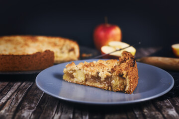 Slice of traditional European apple pie with topping crumbles on plate