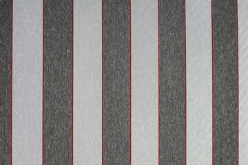 Close-up of a light-dark grey awning fabric with red stripes