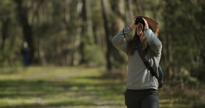Smiling girl bird watching in South Carolina forest