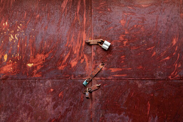 Rusty garage door is closed with three locks