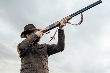 Vintage hunter walks. Rifle Hunter Silhouetted in Beautiful Sunset or Sunrise. Hunter aiming rifle...