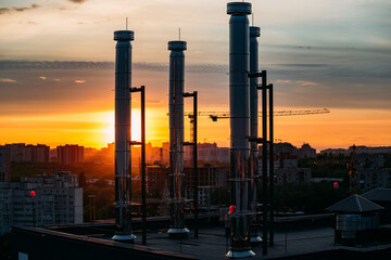 Modern rooftop with ventilation pipes on evening sunset