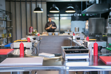 interior in the school of cooking electric stoves, knives, boards laid out on the tables
