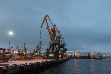 Obraz premium General view of the cargo port. Cargo cranes await the arrival of the vessel for loading unloading coal in the seaport.