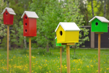 Birdhouse of yellow color on a background of red birdhouses
