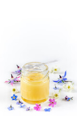Fototapeta na wymiar Raw organic royal jelly in a small bottle with litte spoon on small bottle on white background,