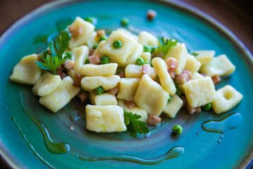 gnocchi with green peas and bacon served on a beautiful plate