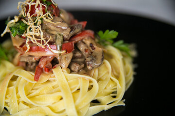 pasta with roasted veal in a creamy sauce with vegetables served on a plate