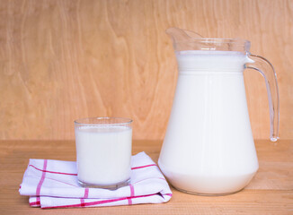 Tasty fresh milk on a wooden background. Carafe with milk and a glass of milk, cottage cheese. view from above. copy space