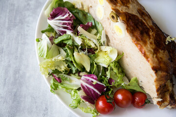 stuffed chicken baked in the oven served on a plate with salad