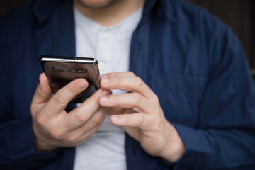Man using smartphone, detail of hands.