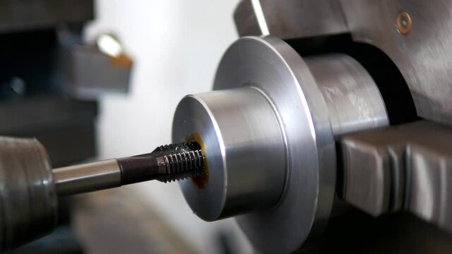 Close up of Internal threading process. With thread cutting, the piece is held in a chuck. Lathe internal thread milling on a shaft
