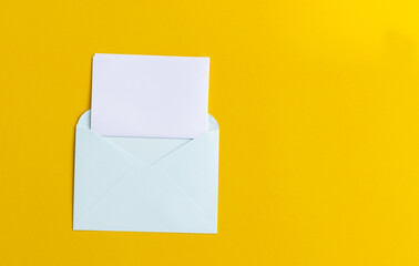 white sheet of paper folds and gets into envelope on yellow background, communication concept.