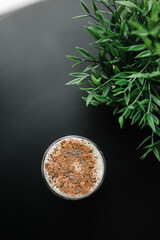 milkshake in a glass glass on a black table against a background of plush cakes