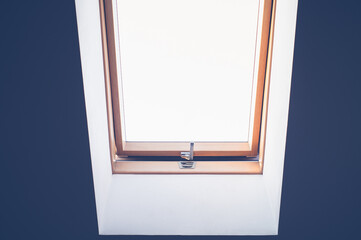 the window in the middle in the ceiling of the room is ajar