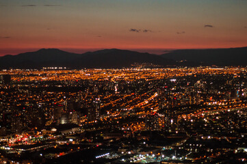 Ciudad de noche con luces encendidas entre montañas