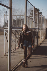 Beautiful girl with long hair walks and poses in a city park in early spring or autumn