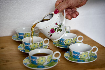 Preparation of a delicious Colombian café traditionally filtered with fabric. On the table implements necessary for its preparation and how to serve it.
