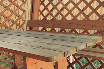 Eco-friendly patio with a wooden table and a fence from vertical boards. Eco-friendly patio close up.
