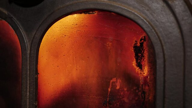 Flames through gritty cast iron stove glass