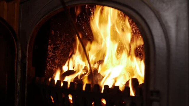 Door of stove opening and stoking hot coals
