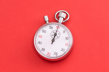 Analogue metal stopwatch on the blue background.