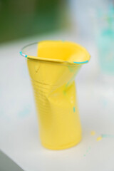 Abstraction from colored paint in plastic cups and brushes. Art of children