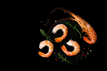 Four king prawns on a black background. Seafood on a black background with place for text.  