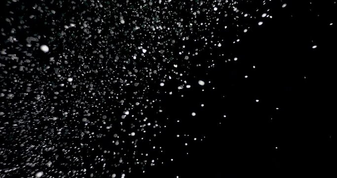 Strong snow blizzard blowing from different directions over an isolated black background