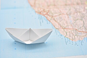Barco de papel sobre un mapa del mundo difuminado
