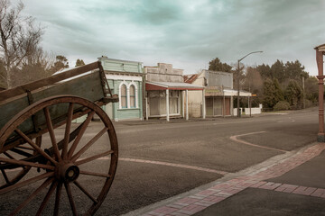 Old buildings and cart wheel in street in Eltham, Taranaki.