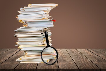 File folders with documents and magnifying glass on the desk
