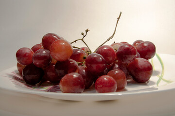 beautiful ripe juicy grapes on a white plate close-up on a white background